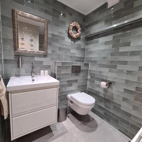 a bathroom with a toilet and a sink and a mirror at d'AldeSkoalle in Molkwerum
