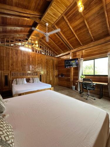 a bedroom with a bed and a desk in a room at Oasis Manzanillo Del Mar in Manzanillo del Mar