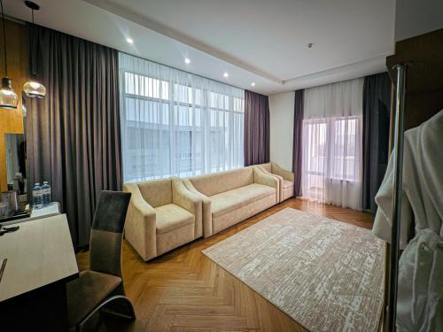 a living room with a couch and a large window at Astra City Hotel in Almaty