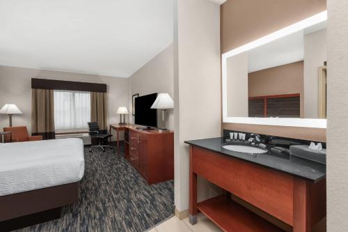 a hotel room with a bed and a large mirror at La Quinta by Wyndham Midwest City - Tinker AFB in Midwest City