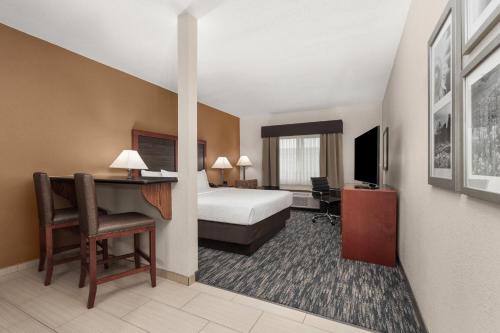 a hotel room with a bed and a desk at La Quinta by Wyndham Midwest City - Tinker AFB in Midwest City