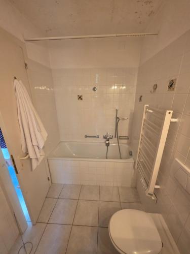 a bathroom with a toilet and a bath tub at Appartement 188m2 in Crans-Montana