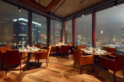 a restaurant with tables and chairs and a view of a city at Novotel London Canary Wharf in London