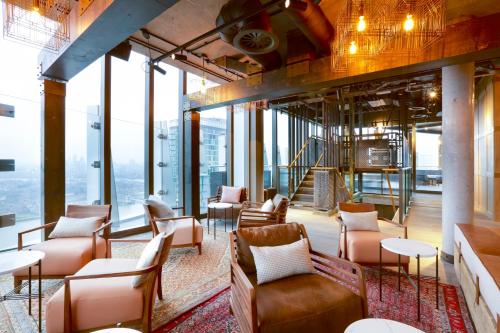 a lobby with chairs and tables and windows at Novotel London Canary Wharf in London