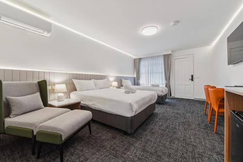 a hotel room with two beds and a couch at Frankston Bay Motel in Frankston