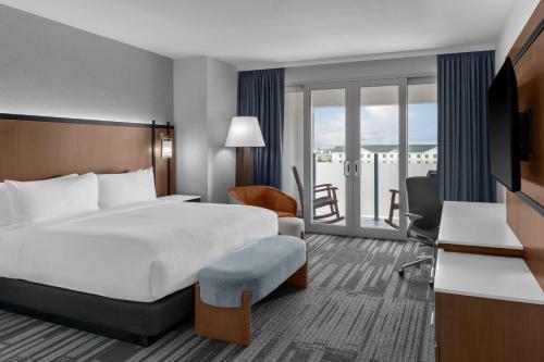 a hotel room with a bed and a balcony at Doubletree By Hilton Midland West Loop I-250 in Midland