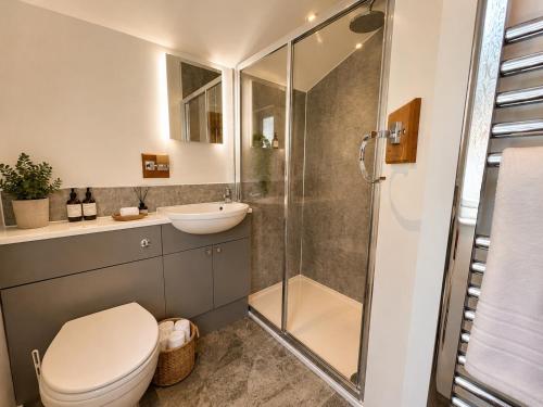 a bathroom with a shower and a toilet and a sink at Seaside Escape in Westward Ho! 3-Bed Family Holiday Home with Sea Views in Westward Ho
