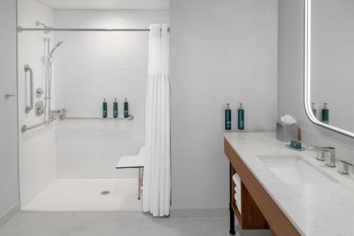 a white bathroom with a shower and a sink at Doubletree By Hilton Midland West Loop I-250 in Midland
