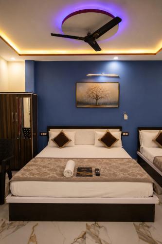 a bedroom with a large bed with a ceiling fan at Hotel New Residency Ayodhya in Ayodhya