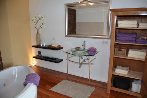 ein Badezimmer mit einer Badewanne und einem Glastisch in der Unterkunft Designerwohnung Maria Plain in Radeck