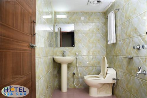 a bathroom with a toilet and a sink at Hotel Sea Cox in Cox's Bazar