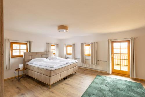 a bedroom with a large bed and a green rug at Ferienhaus - Großer Büchelstein in Grattersdorf