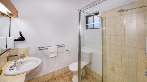 a bathroom with a sink and a toilet and a shower at The Cottage Motor Inn Albury CBD in Albury