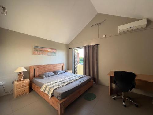 a bedroom with a bed and a desk and a chair at Vanz Villa in Mont Choisy