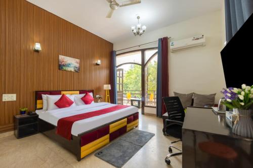 a bedroom with a bed and a desk and a television at Nook Inn & Suites - 2 Min Walk From MG ROAD METRO in Gurgaon