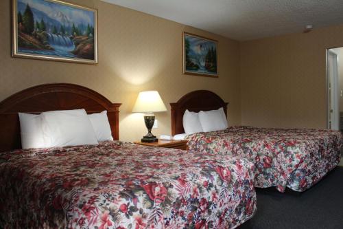 a hotel room with two beds and a lamp at Highlander Motor Inn Atlantic City in Galloway