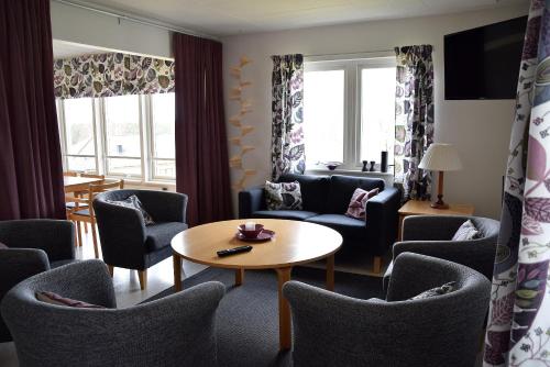 a living room with chairs and a table and a tv at Mullsjö Folkhögskola in Mullsjö