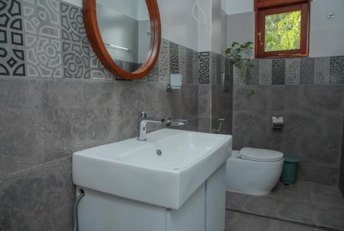 a bathroom with a sink and a toilet and a mirror at Aranya Heights Luxury 7 Pax Home in Wattala