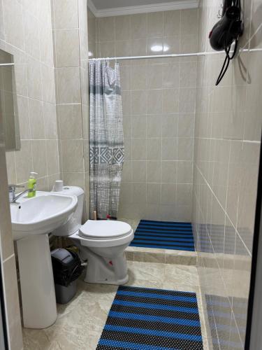 a bathroom with a toilet and a sink and a shower at Гостевой дом Бакай in Imeni Kirova