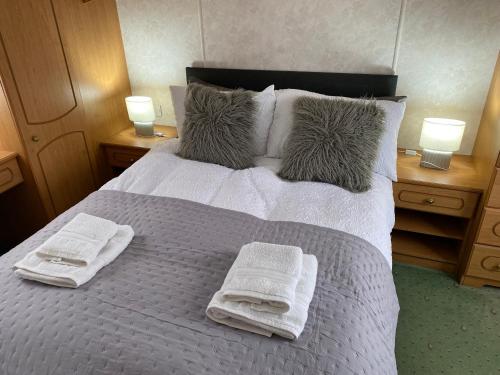 a bedroom with a bed with towels on it at Craigmore Caravan in Coleraine