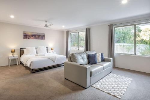 a white bedroom with a bed and a couch at Cockatoo Lodge - Winery Retreat at Rivendell Estate in Yallingup Siding