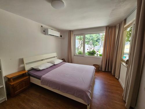 a bedroom with a bed and a large window at Studio Garden City Center Pomorie in Pomorie