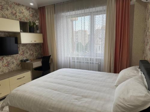 ein Schlafzimmer mit einem großen Bett und einem Fenster in der Unterkunft Flora in Chişinău