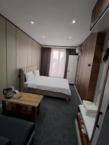 a small room with two beds and a table at Comfort Hotel in Osh
