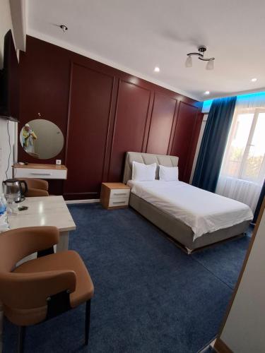 a hotel room with a bed and a table and chairs at Comfort Hotel in Osh