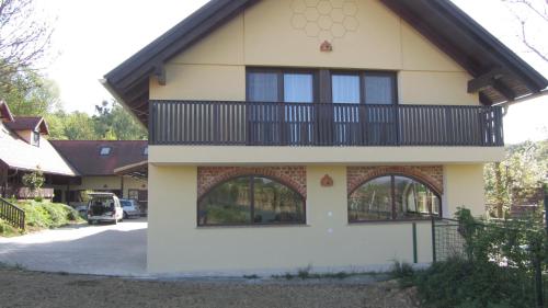 a house with a balcony on the side of it at Turistična Kmetija Čebelji Gradič in Rogašovci