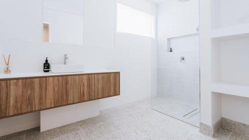 a white bathroom with a sink and a shower at Blissful Escape in Portsea