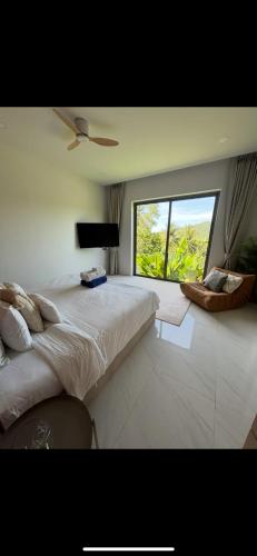 a bedroom with a large bed and a large window at Modern Jungle Pool Villa in Mae Nam