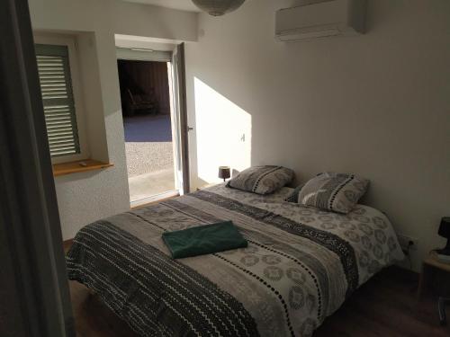a bedroom with a bed with a green pillow on it at Meublé Climatisé 75 M2 in Souvans