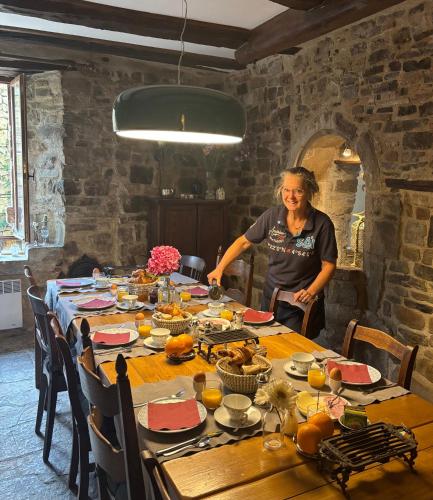 a woman standing in front of a table with food at La Maison aux Puits in Cordes-sur-Ciel