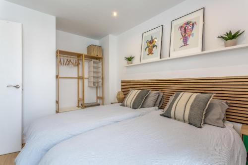 two beds in a bedroom with white walls at Salitre y lava in Corralejo