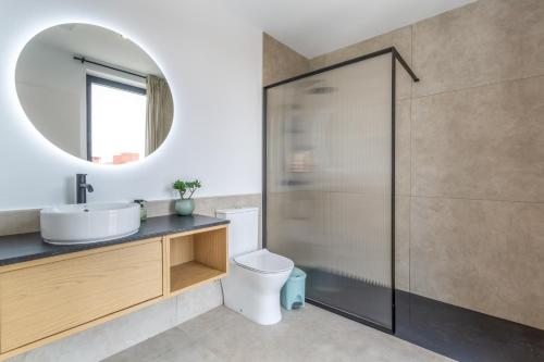a bathroom with a toilet and a sink and a mirror at Salitre y lava in Corralejo