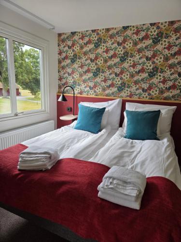 a bedroom with a large bed with towels on it at Bommersvik Hotell & Konferens in Järna
