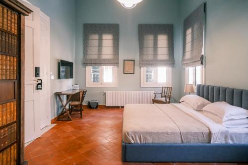 a bedroom with a bed and a desk and windows at Beit Toureef - SARAYA HALA 'PALATIAL' in Beirut