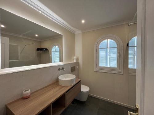 a bathroom with a sink and a toilet and a mirror at Casa Vista del Mar 1 in Morro del Jable