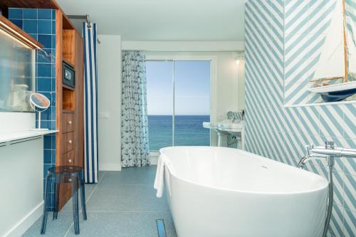 a bathroom with a tub and a view of the ocean at The Salmar - Adults Only in San Miguel de Abona