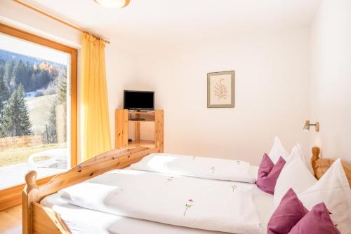 a bedroom with a bed and a large window at Lettnerhof bnb Family Suite 2 in Monguelfo