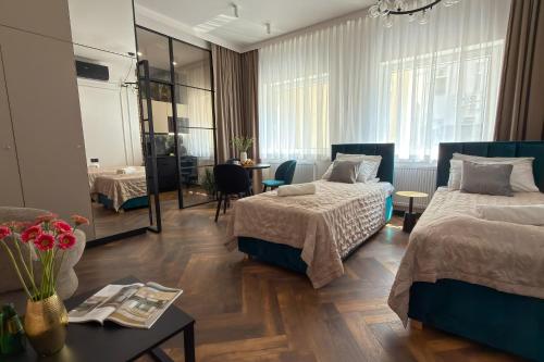 a hotel room with two beds and a table at Deco Apartments Mariacka 8 - apartamenty w centrum Katowic in Katowice