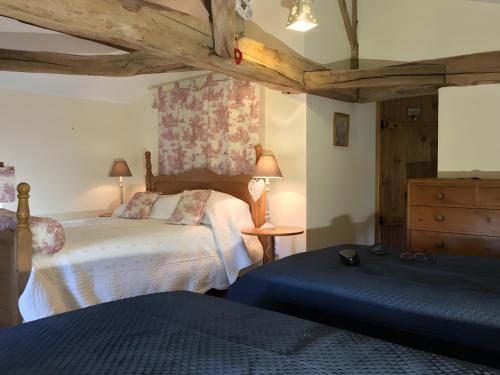 a bedroom with two beds and a table with lamps at Maison Les Fleuries in Saint-Quentin-de-Chalais
