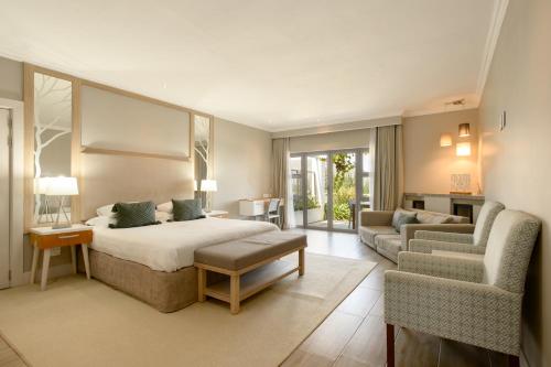a bedroom with a bed and a couch and a chair at Stellenbosch Luxury Apartments in Stellenbosch