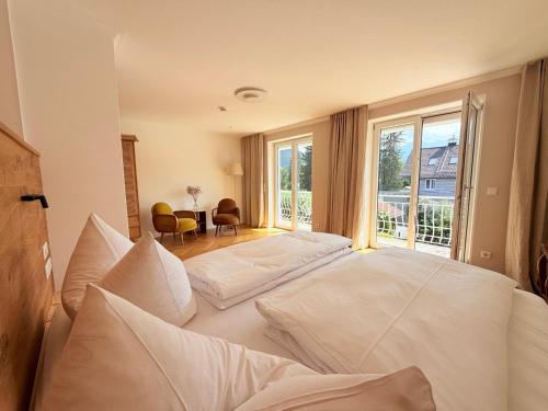 a large white bed with pillows in a bedroom at Alpenzeit - Ferienhaus mit Sauna, Garten und Bergblick bei Garmisch-Partenkirchen in Farchant