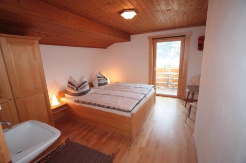 ein Schlafzimmer mit einem Bett und ein Bad mit einem Fenster in der Unterkunft Oberhuber in Vandans