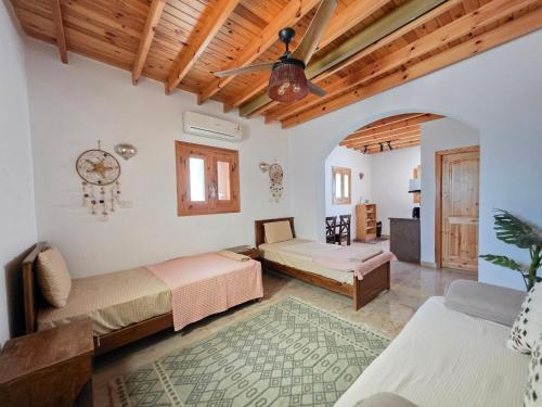 a bedroom with two beds and a ceiling fan at Villa Vovan in Dahab