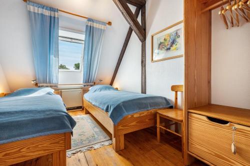 two beds in a room with a window at Schwalbennest in Trebel