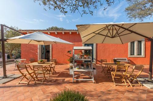 two tables and chairs with umbrellas on a patio at Domos Pintadas -Happy Rentals in Rudalza