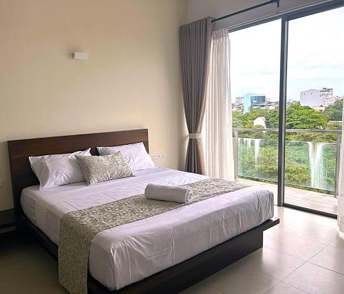 a bedroom with a bed and a large window at Water Park Suites in Nugegoda
